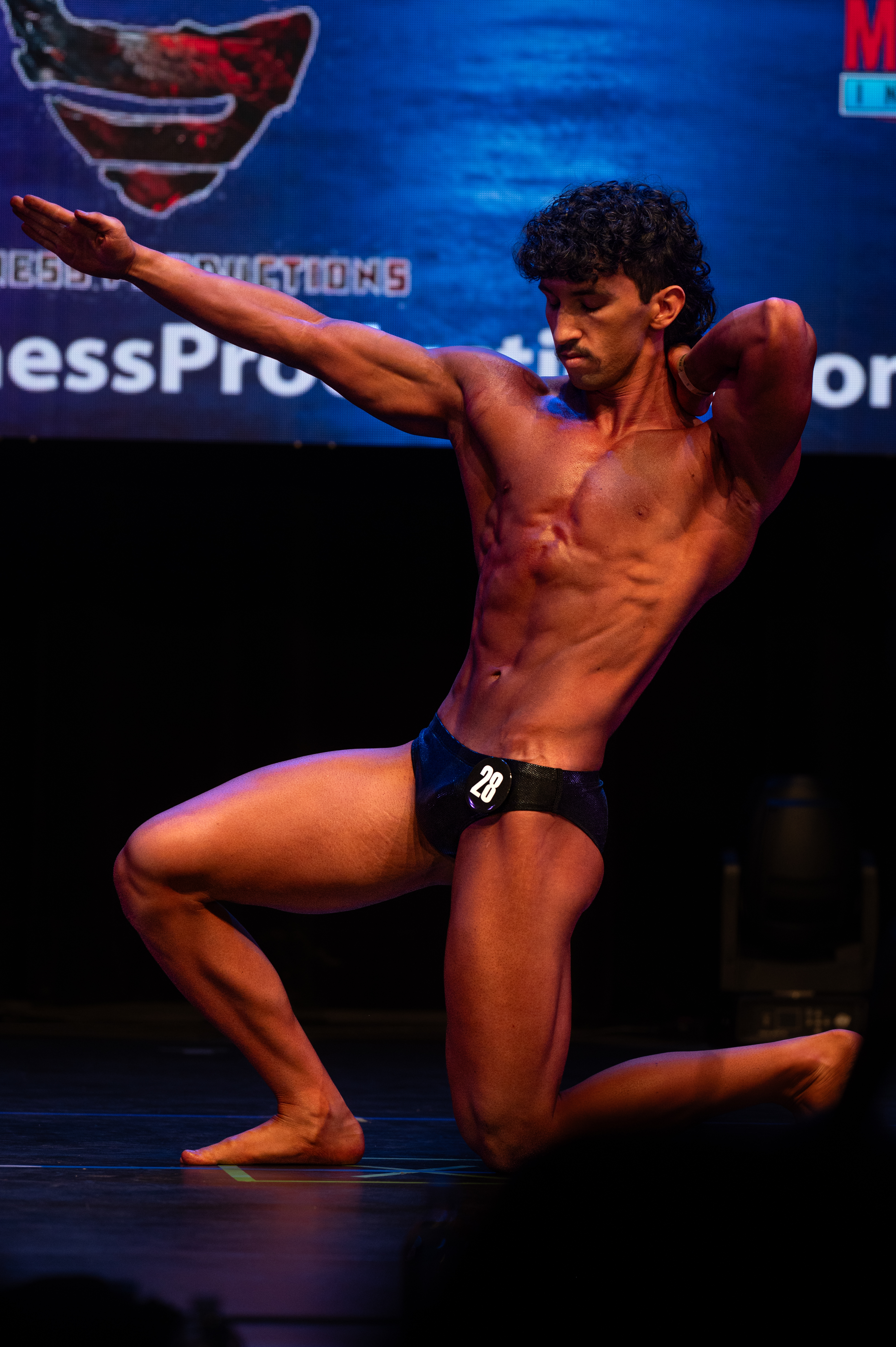 Bodybuilder creative pose on stage